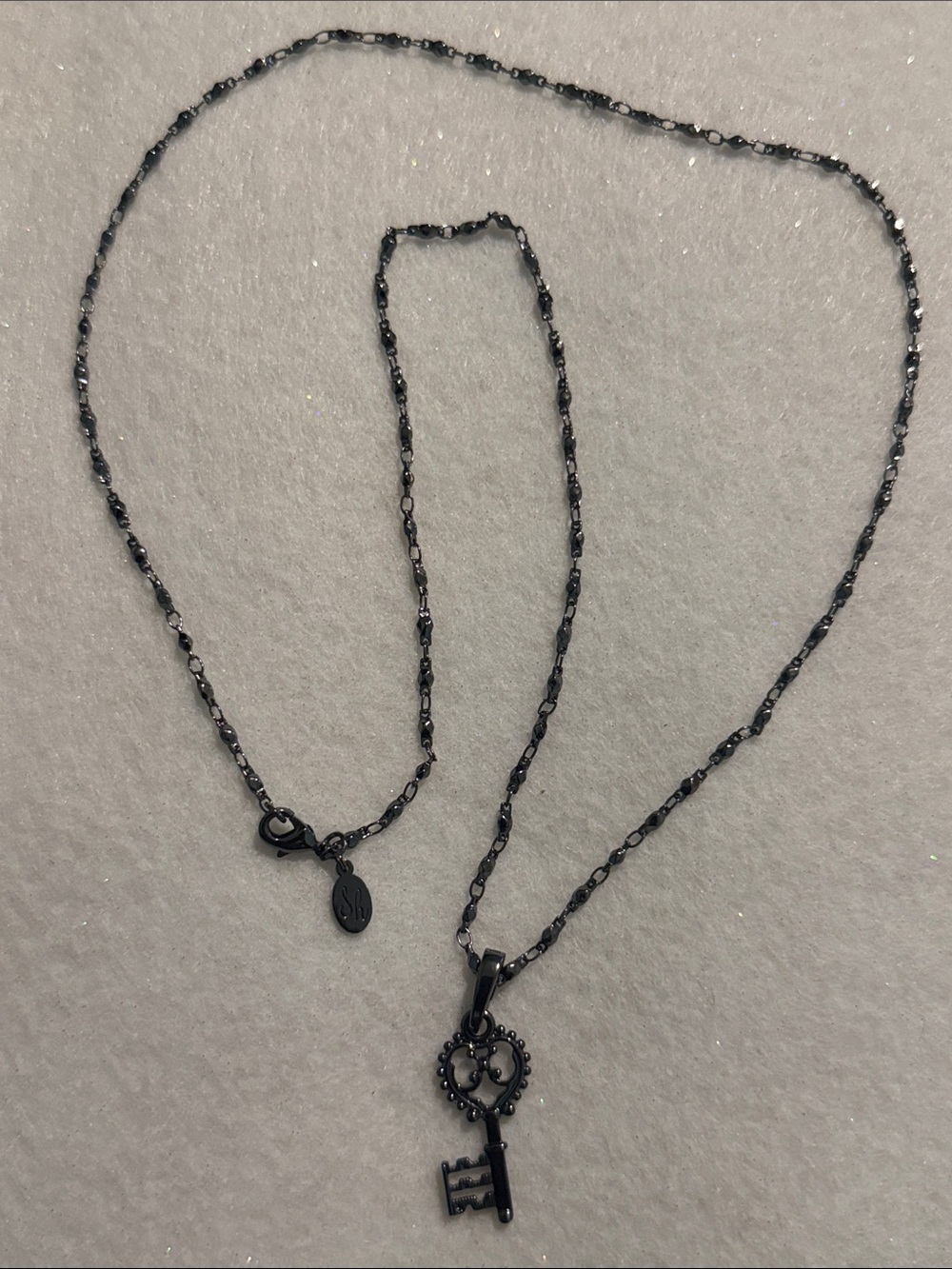 Black Key Pendant Necklace with Decorative Heart Accent